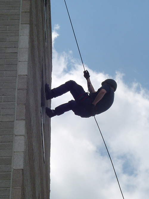 Officer repelling down a building