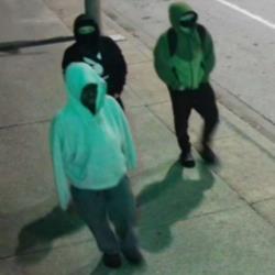 Image of three suspects in white, black, and grey or green hoodies.